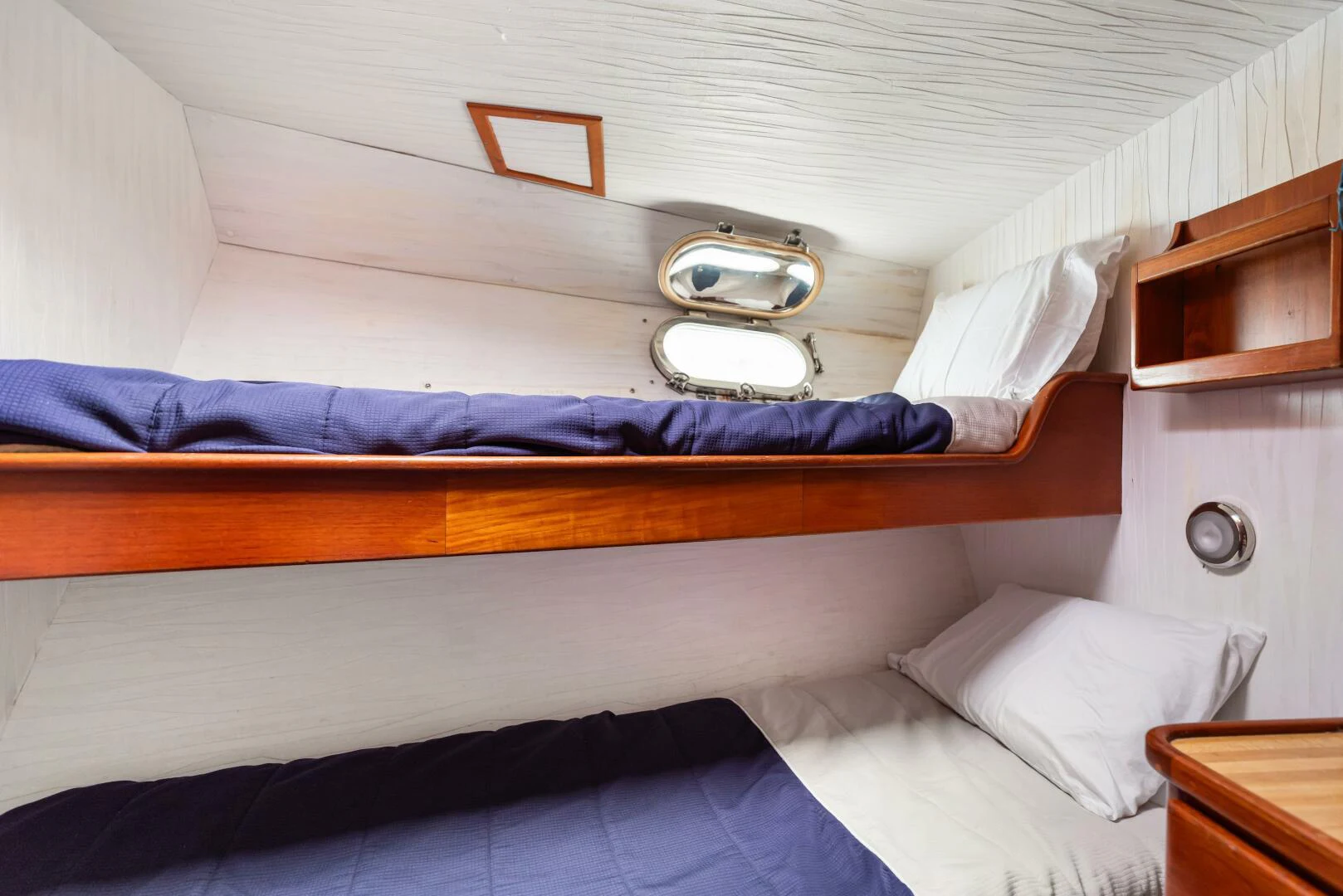 a bed with a blue comforter aboard HUNTRESS Yacht for Sale