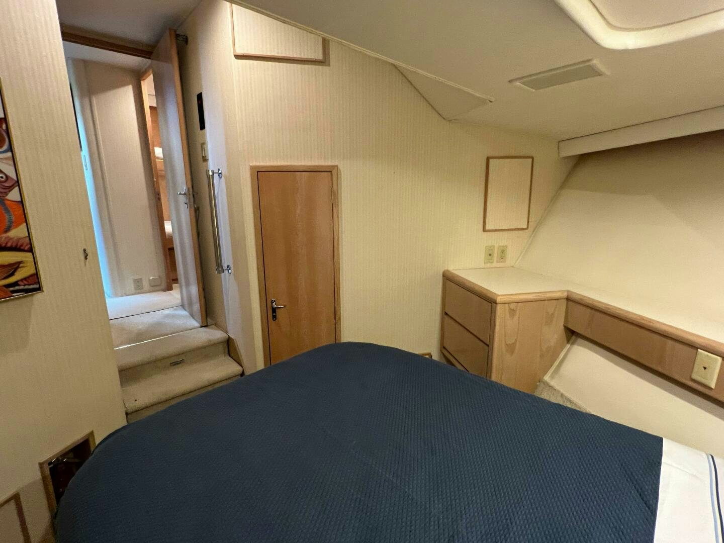 a bedroom with a bed and a dresser aboard AT EASE Yacht for Sale