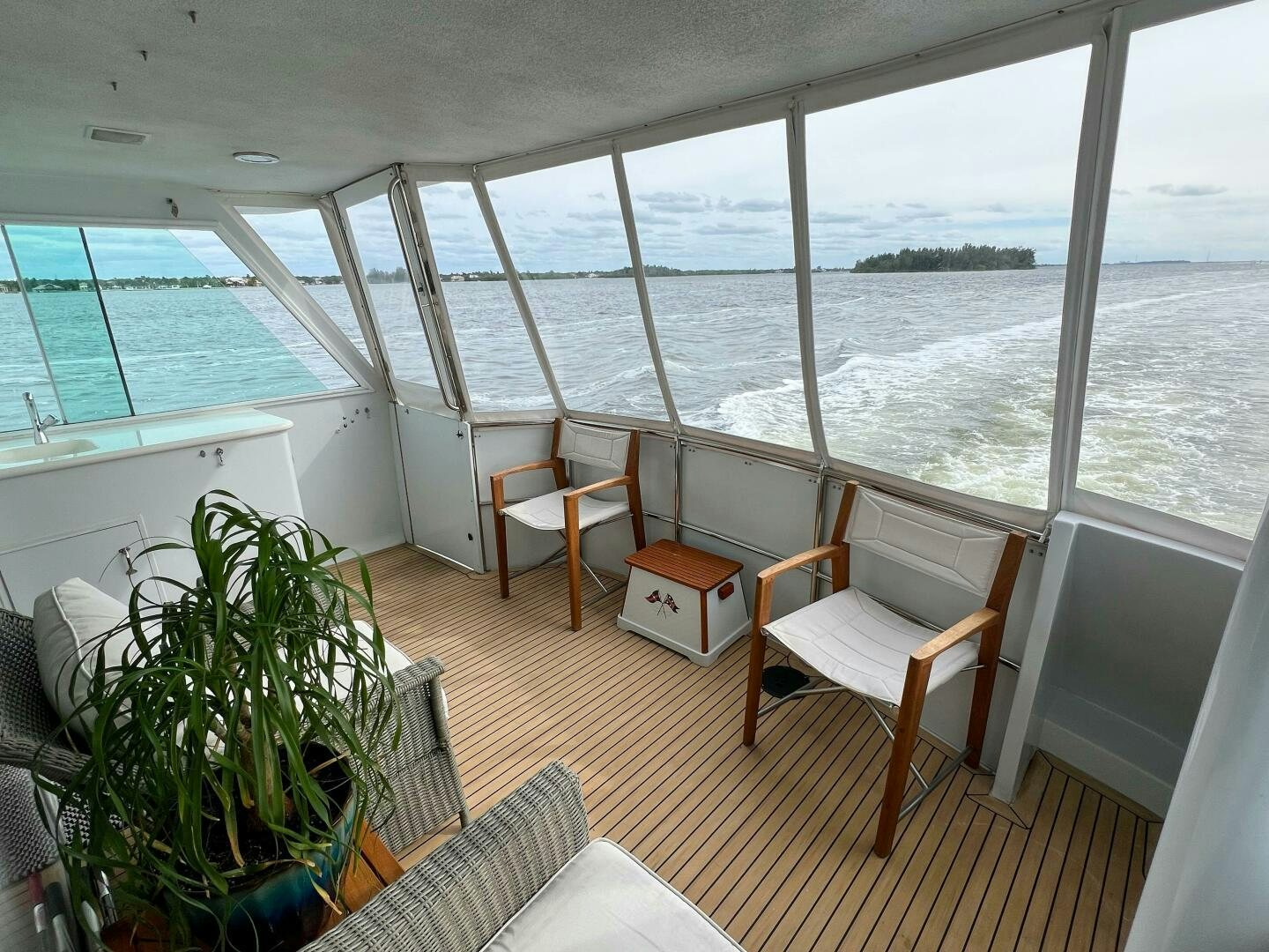 a deck with chairs and plants aboard AT EASE Yacht for Sale