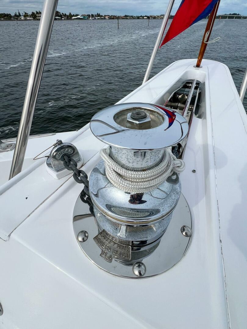 a white boat with a red and blue sail on the water aboard AT EASE Yacht for Sale