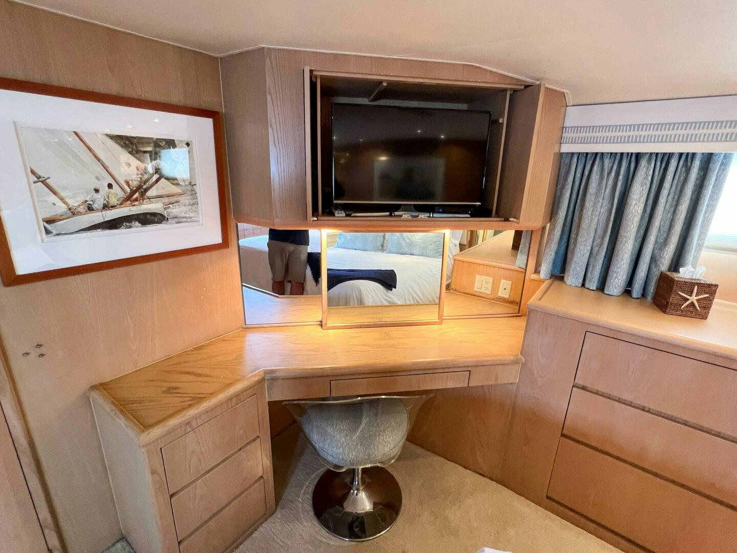 a room with a tv and a shelf with pictures on it aboard AT EASE Yacht for Sale