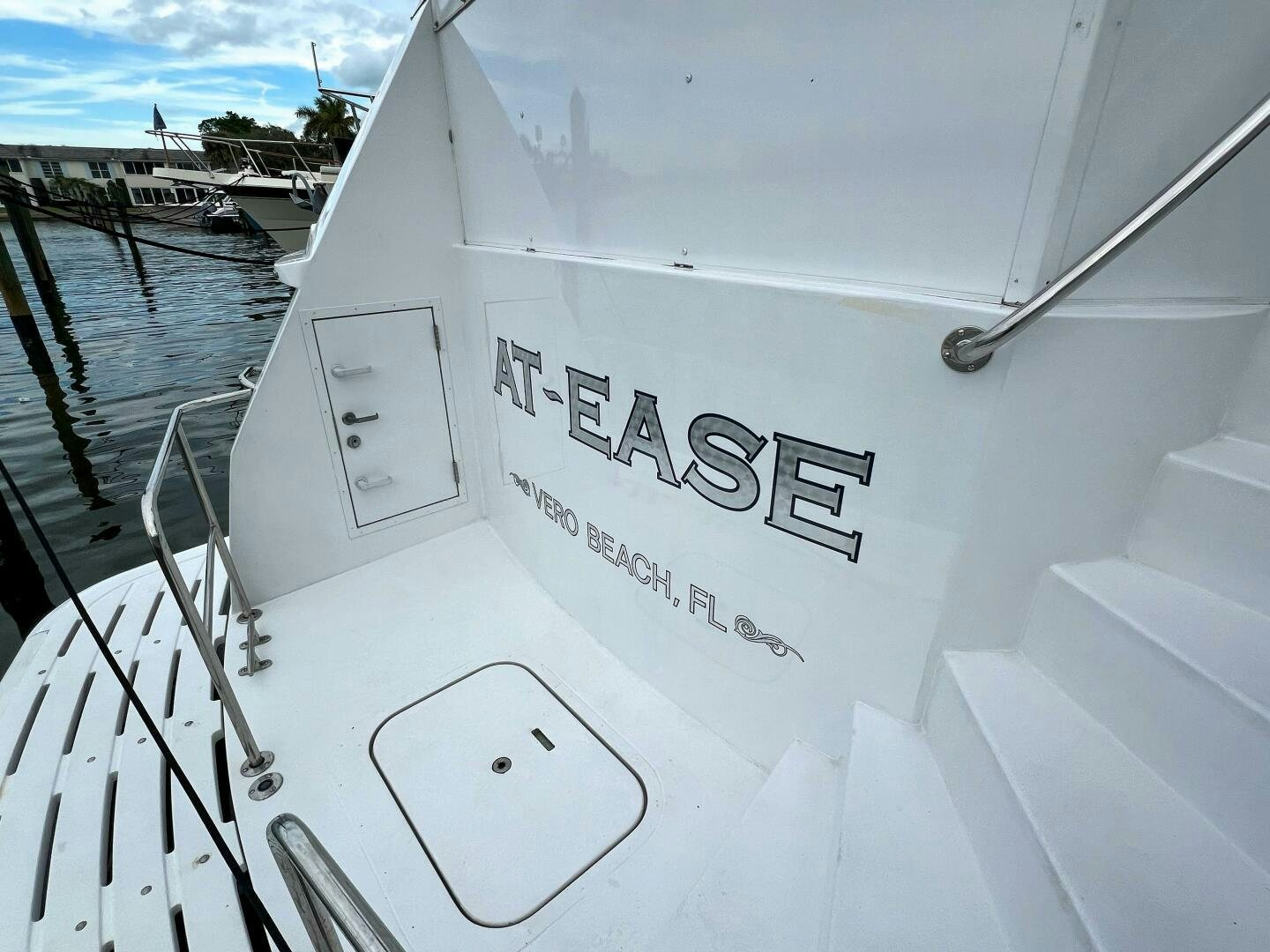 a white boat with black text aboard AT EASE Yacht for Sale