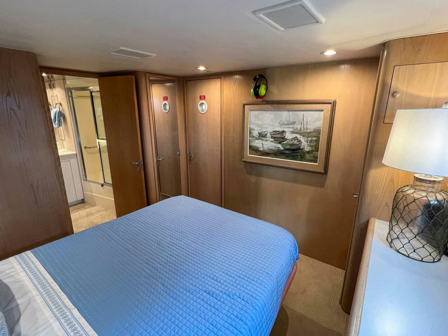 a bedroom with a blue bed spread aboard AT EASE Yacht for Sale
