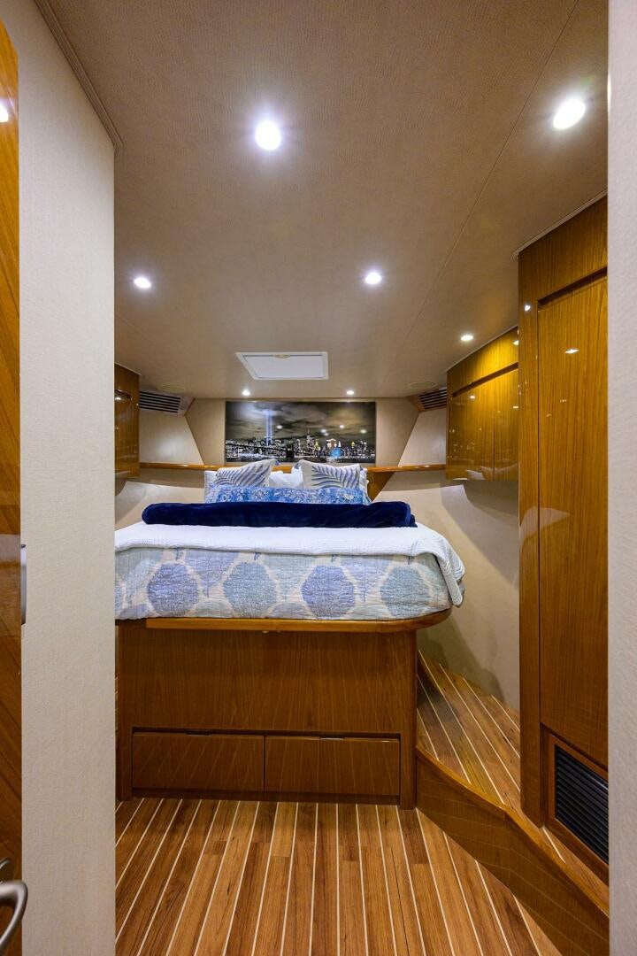 a bedroom with a wood floor aboard CODE BLU Yacht for Sale