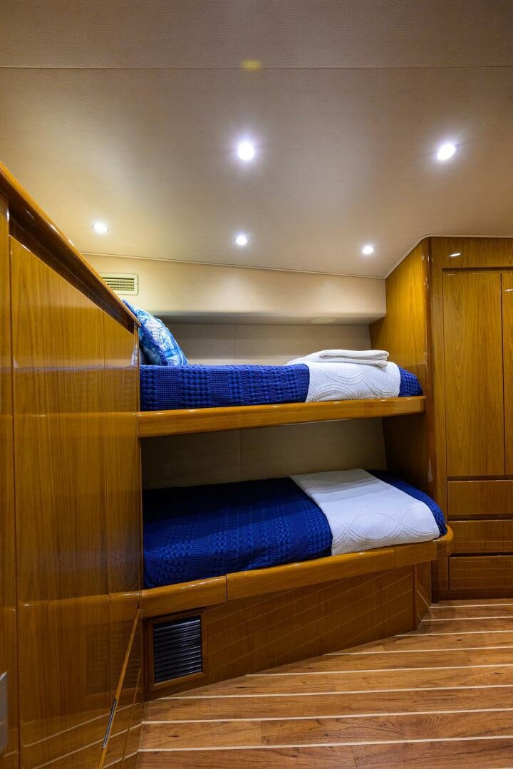 a bunk bed with a blue sheet aboard CODE BLU Yacht for Sale