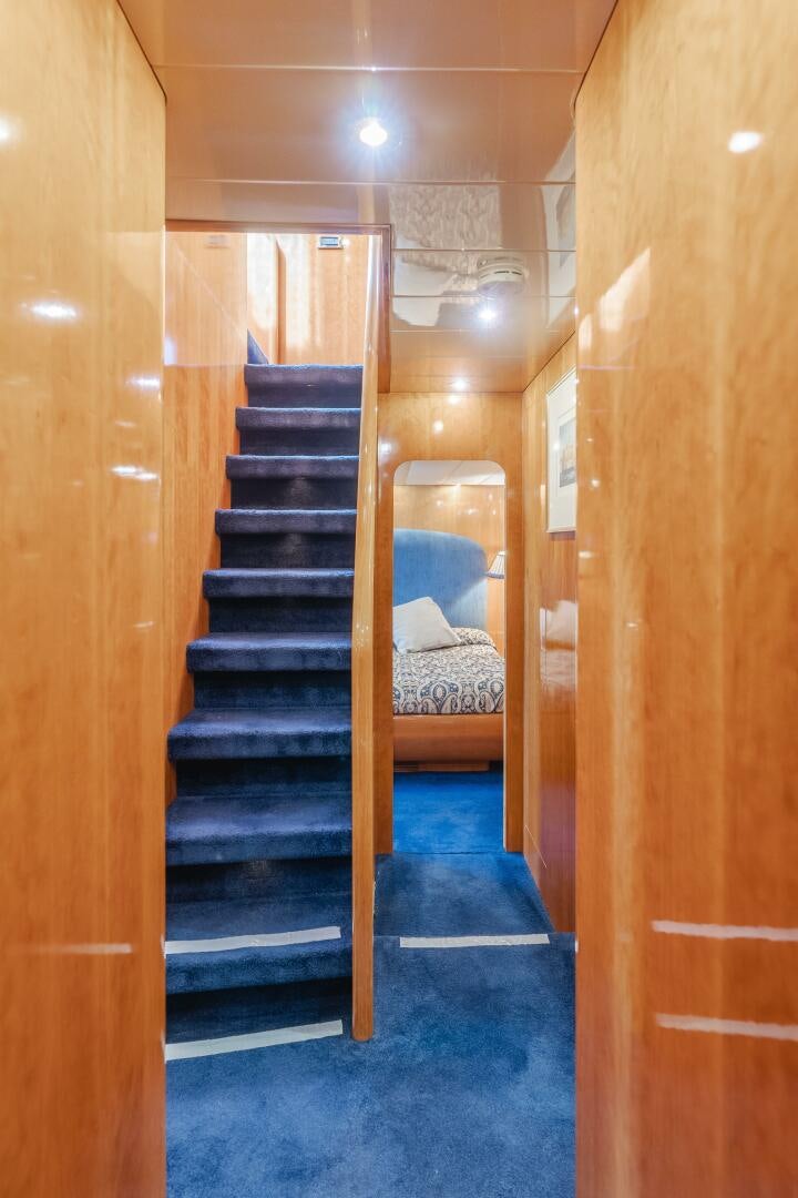 a wooden staircase with a blue carpet aboard C LADY Yacht for Sale