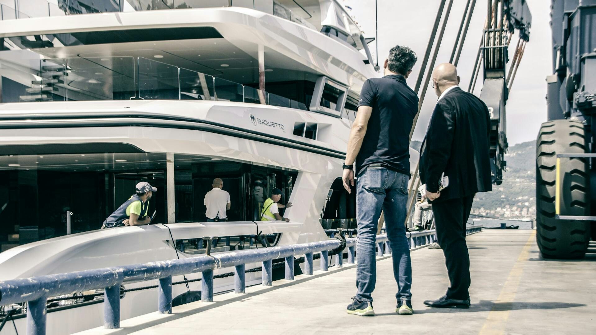 a group of men standing next to a boat aboard BAGLIETTO T52 HULL 4 Yacht for Sale