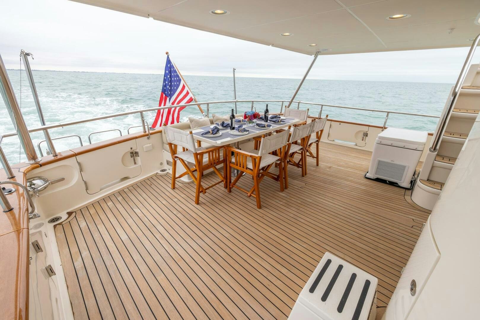 a deck with a table and chairs on it aboard INDIGO Yacht for Sale