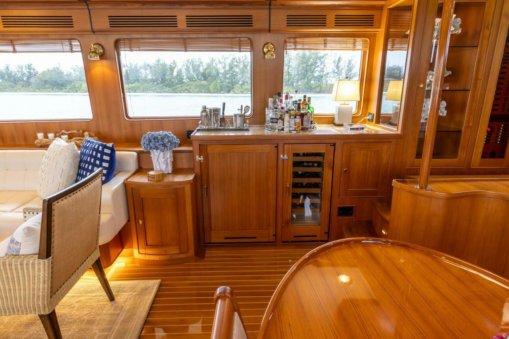 a room with a wood floor and a wood cabinet and a table with chairs and a window with aboard INDIGO Yacht for Sale