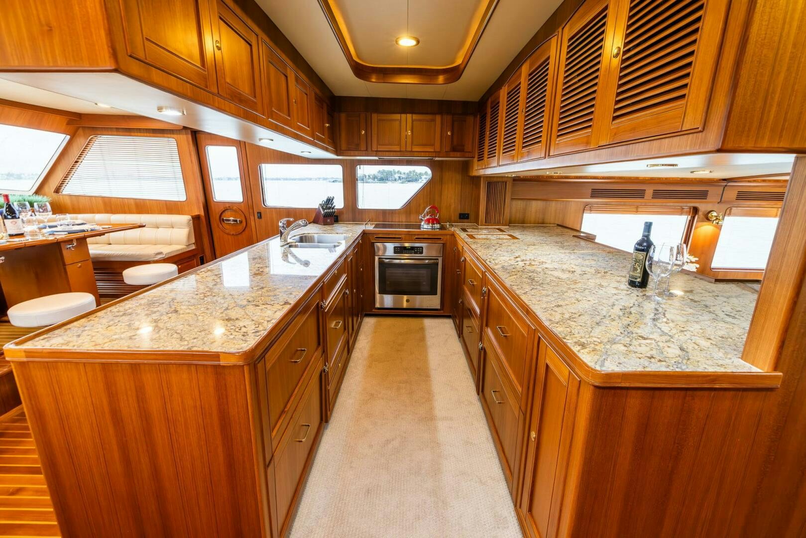 a large kitchen with wooden cabinets aboard INDIGO Yacht for Sale
