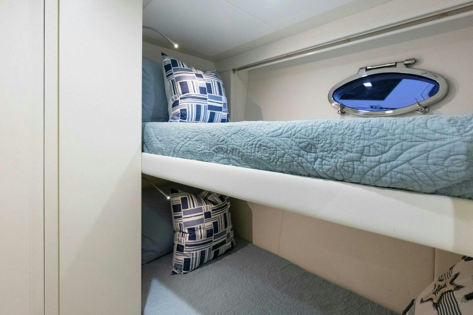 a bed with a blue blanket and a blue pillow aboard PHOENIX RISING Yacht for Sale