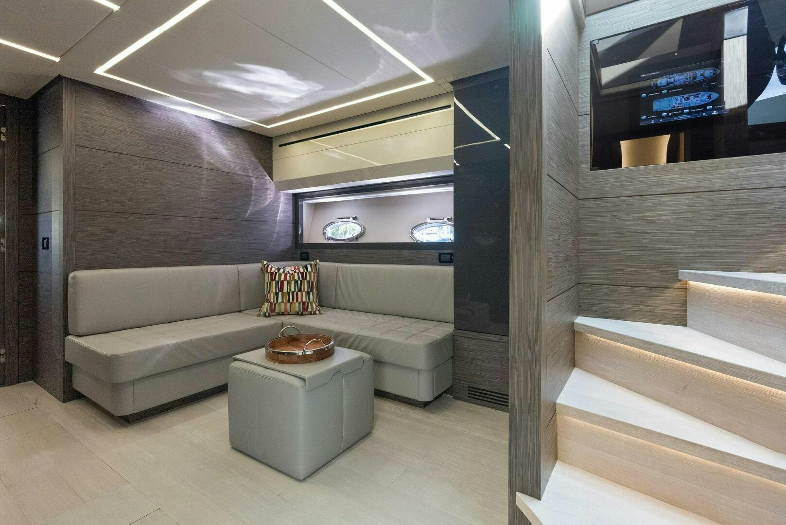 a room with a couch and a tv on the wall aboard PHOENIX RISING Yacht for Sale
