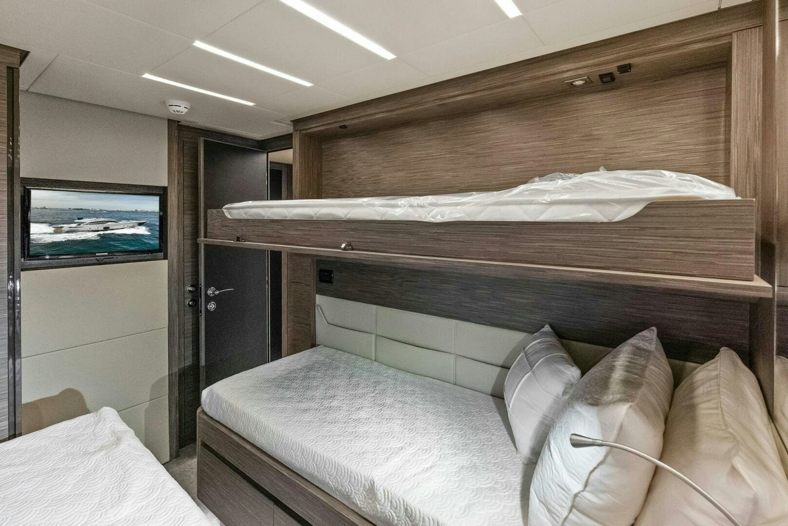 a bed with a television on the wall aboard PHOENIX RISING Yacht for Sale