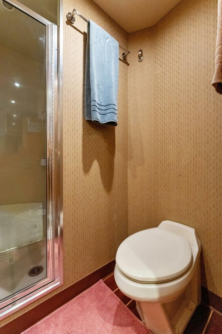 a bathroom with a toilet and a shower curtain aboard ANTARES Yacht for Sale