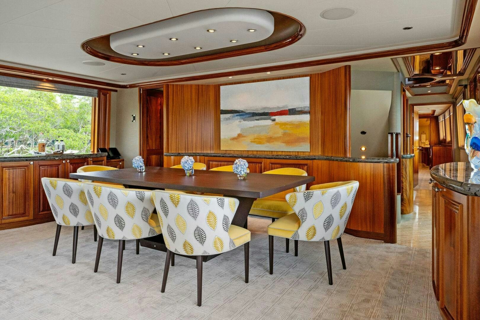 a dining table and chairs in a room with wood cabinets aboard ANTARES Yacht for Sale