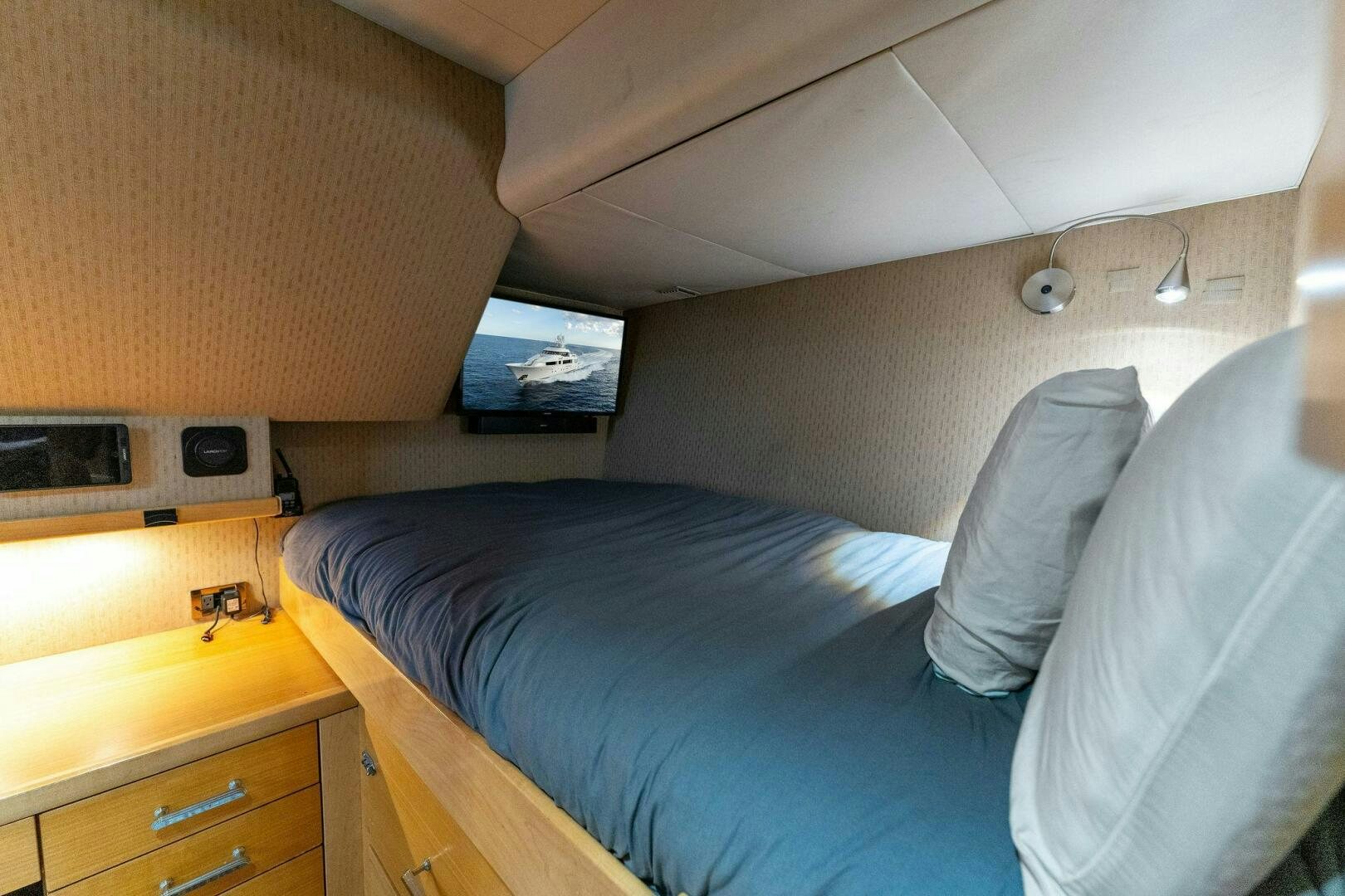 a bed with a television on the wall aboard ANTARES Yacht for Sale