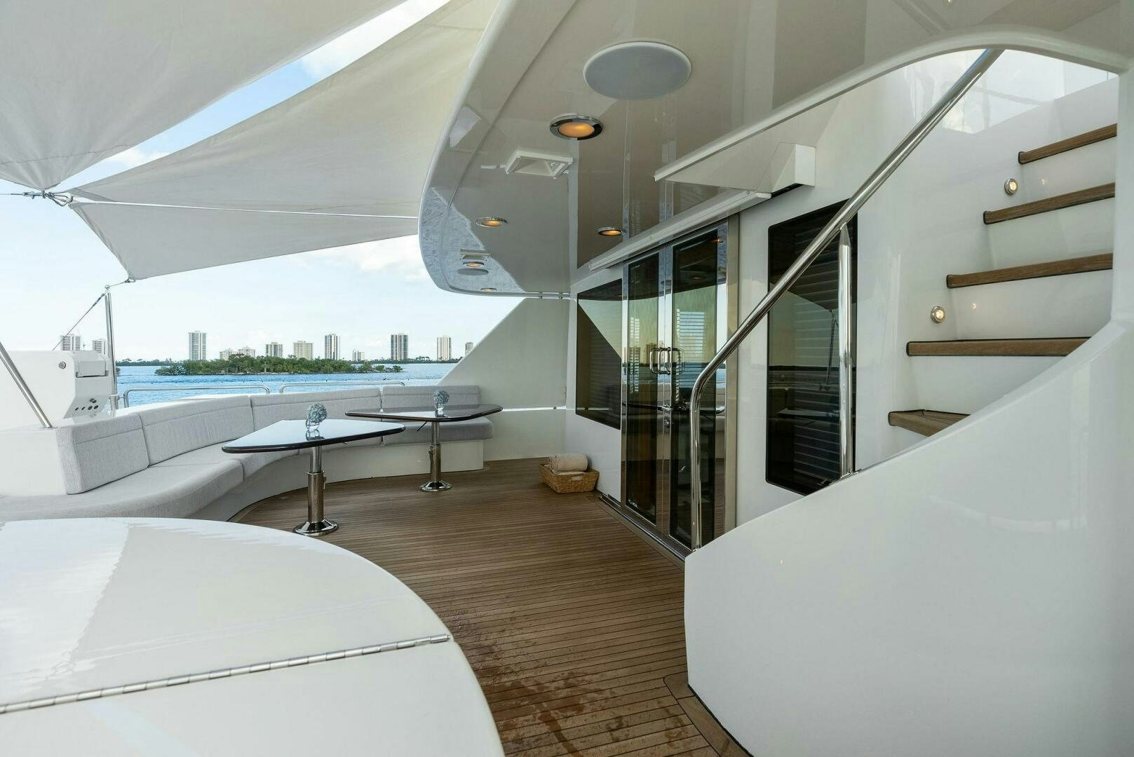 a room with a glass door and a table with chairs and a bed aboard ANTARES Yacht for Sale