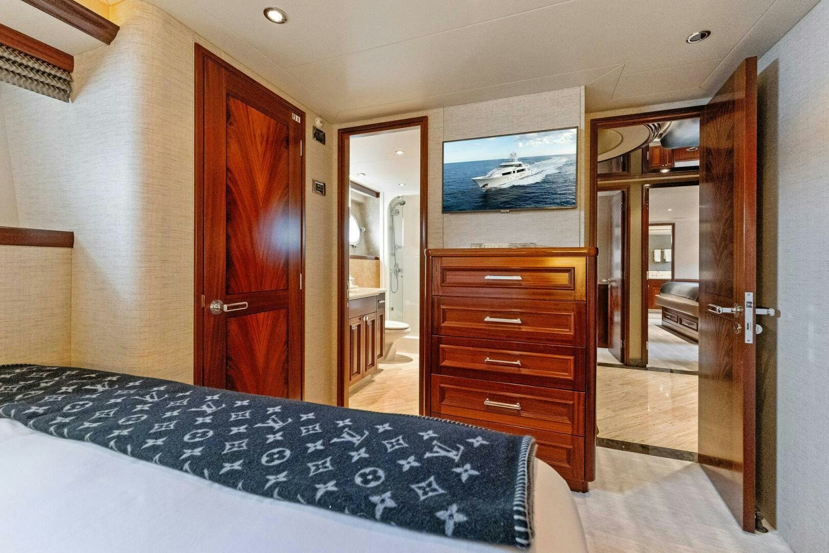 a bedroom with a bed and a television on the wall aboard ANTARES Yacht for Sale