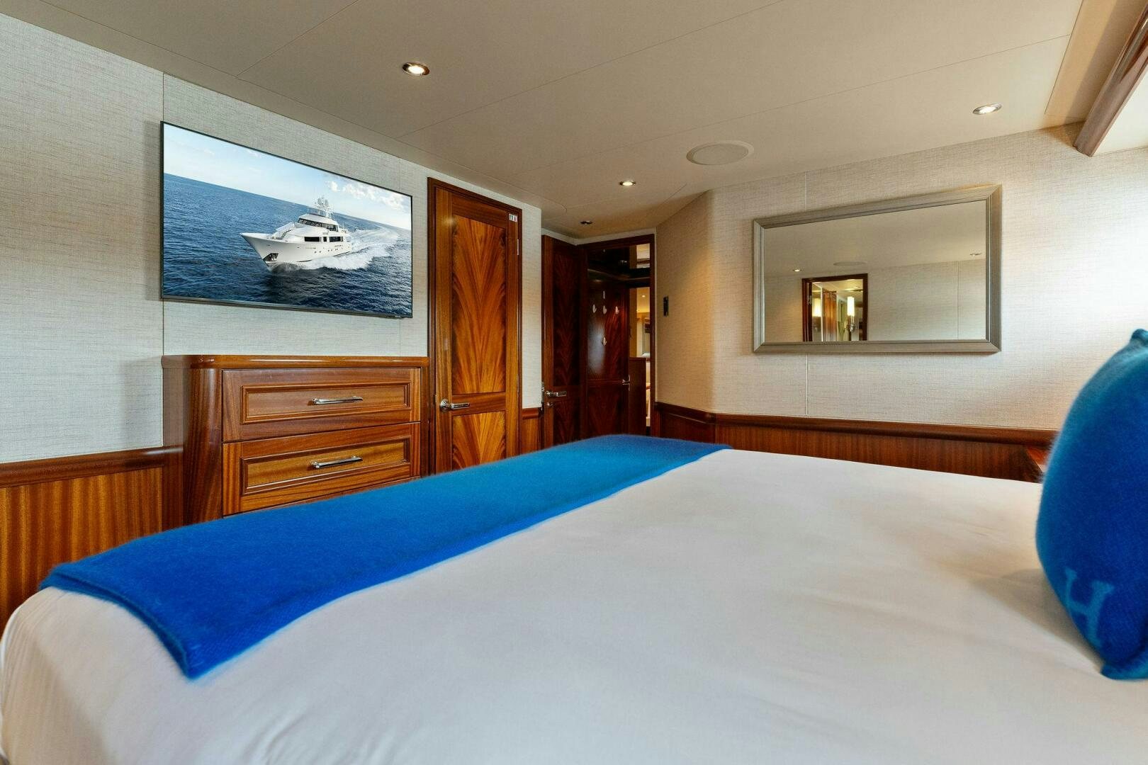 a bedroom with a bed and a television on the wall aboard ANTARES Yacht for Sale