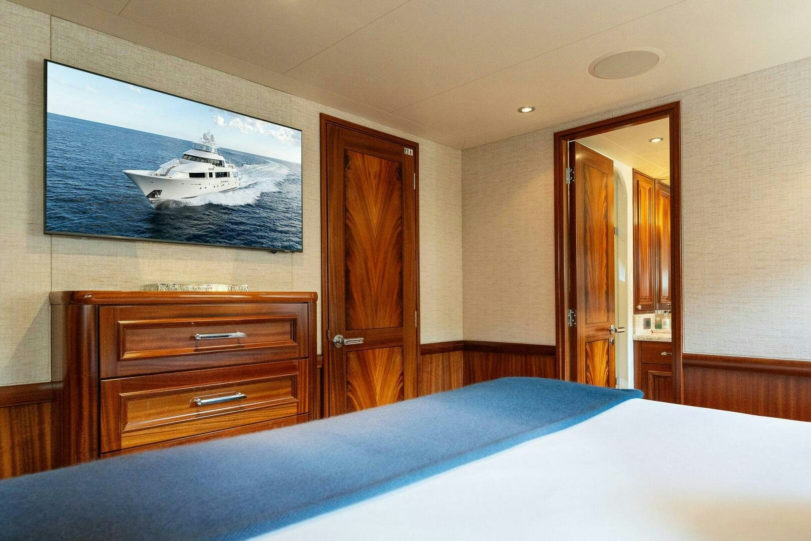 a bedroom with a bed and a television on the wall aboard ANTARES Yacht for Sale