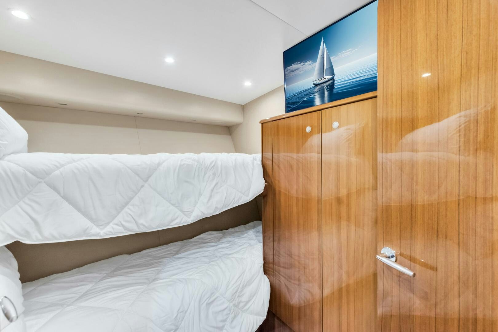 a bed with a television on the wall aboard BERRY BLESSED Yacht for Sale