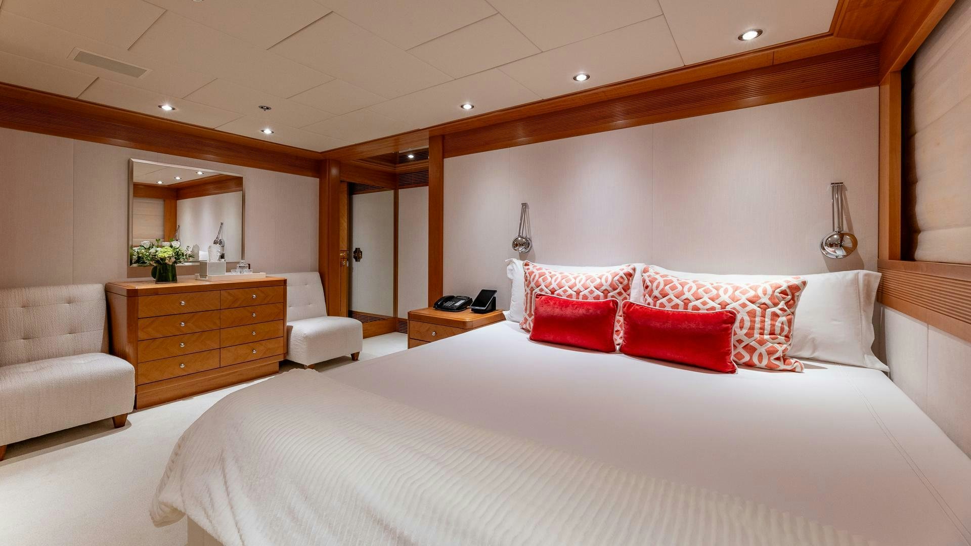 a large bed with red pillows aboard AMANTI Yacht for Sale