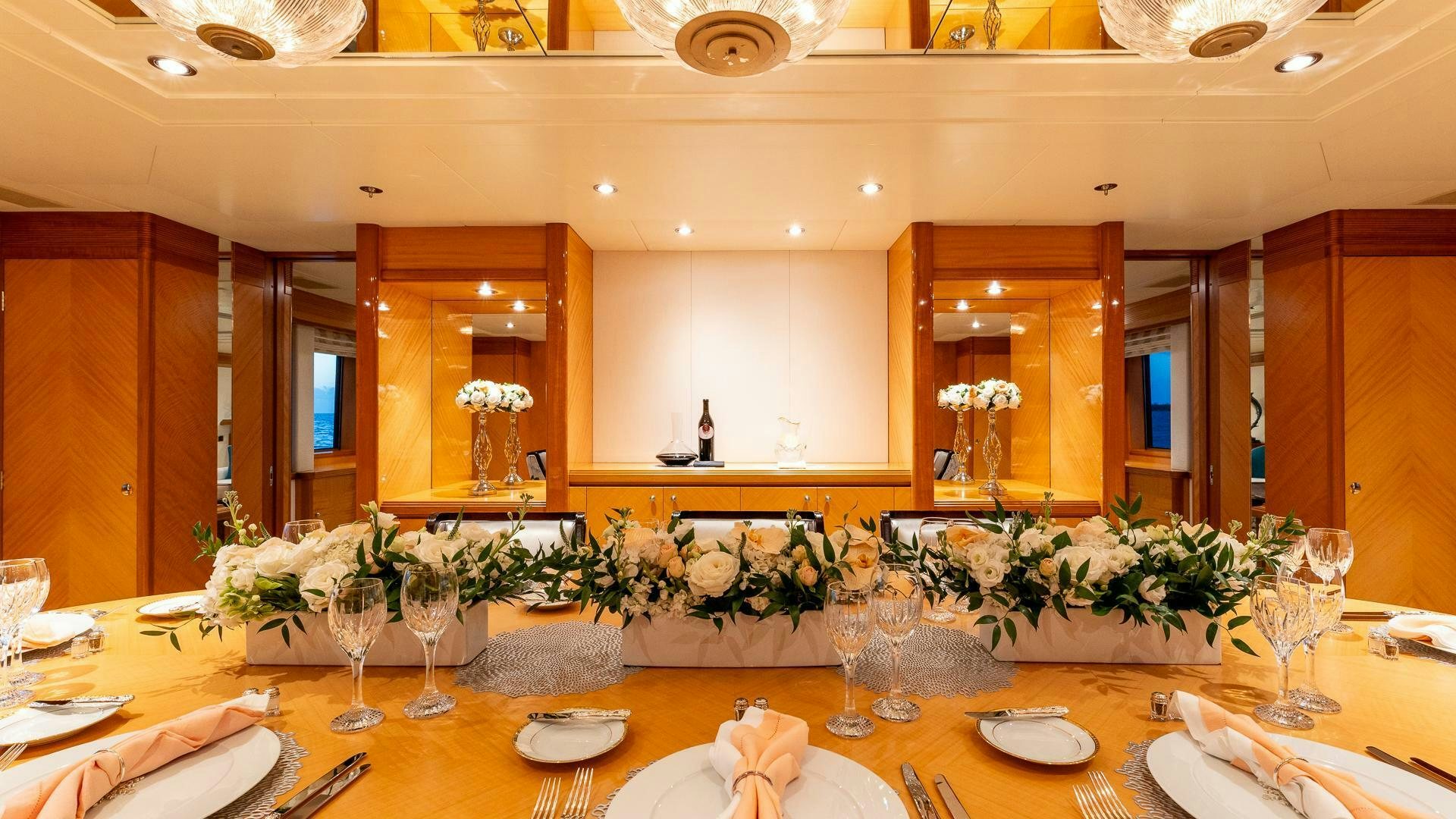a large table with many glasses and plates on it aboard AMANTI Yacht for Sale