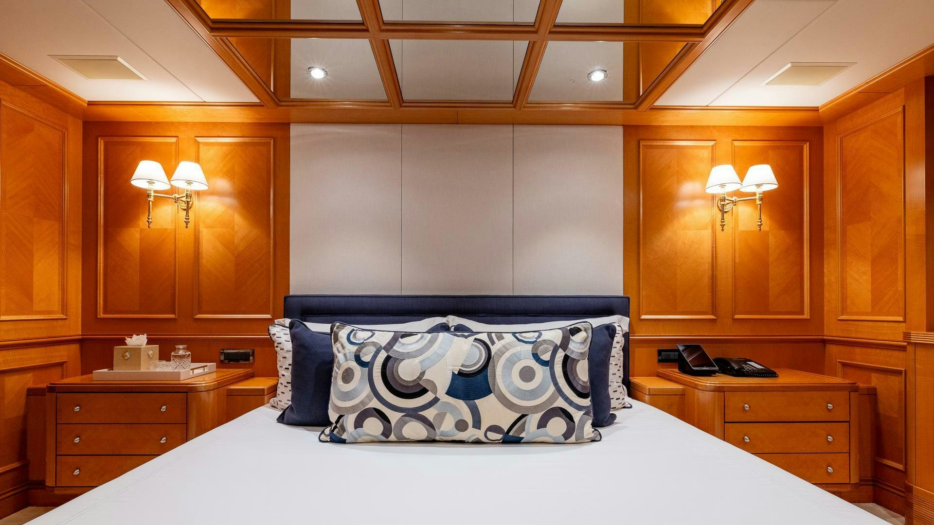 a bed with blue and white pillows aboard AMANTI Yacht for Sale