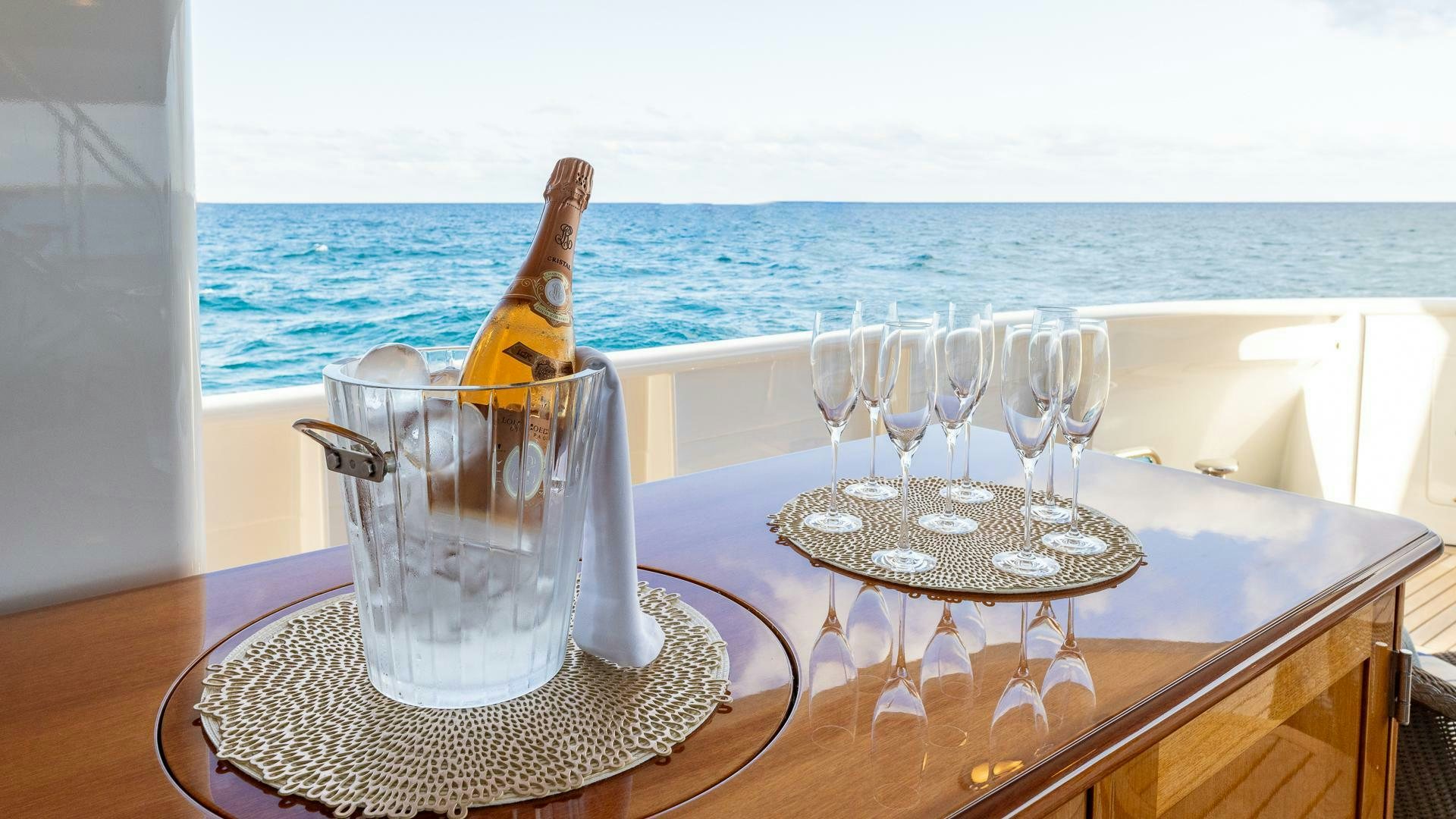 a bottle of champagne on a table with glasses and a bottle of champagne aboard AMANTI Yacht for Sale