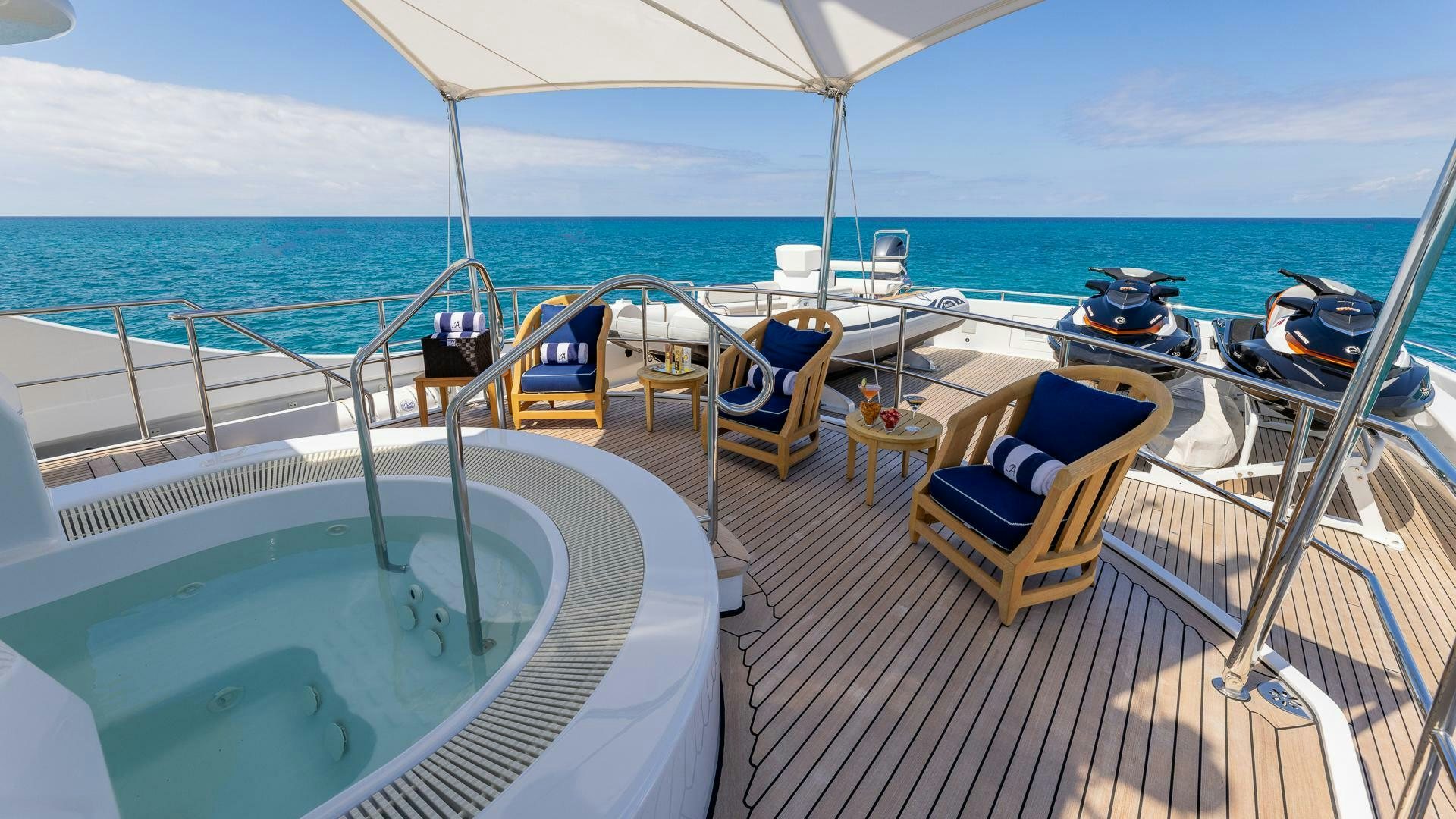 a deck with chairs and a table on it aboard AMANTI Yacht for Sale