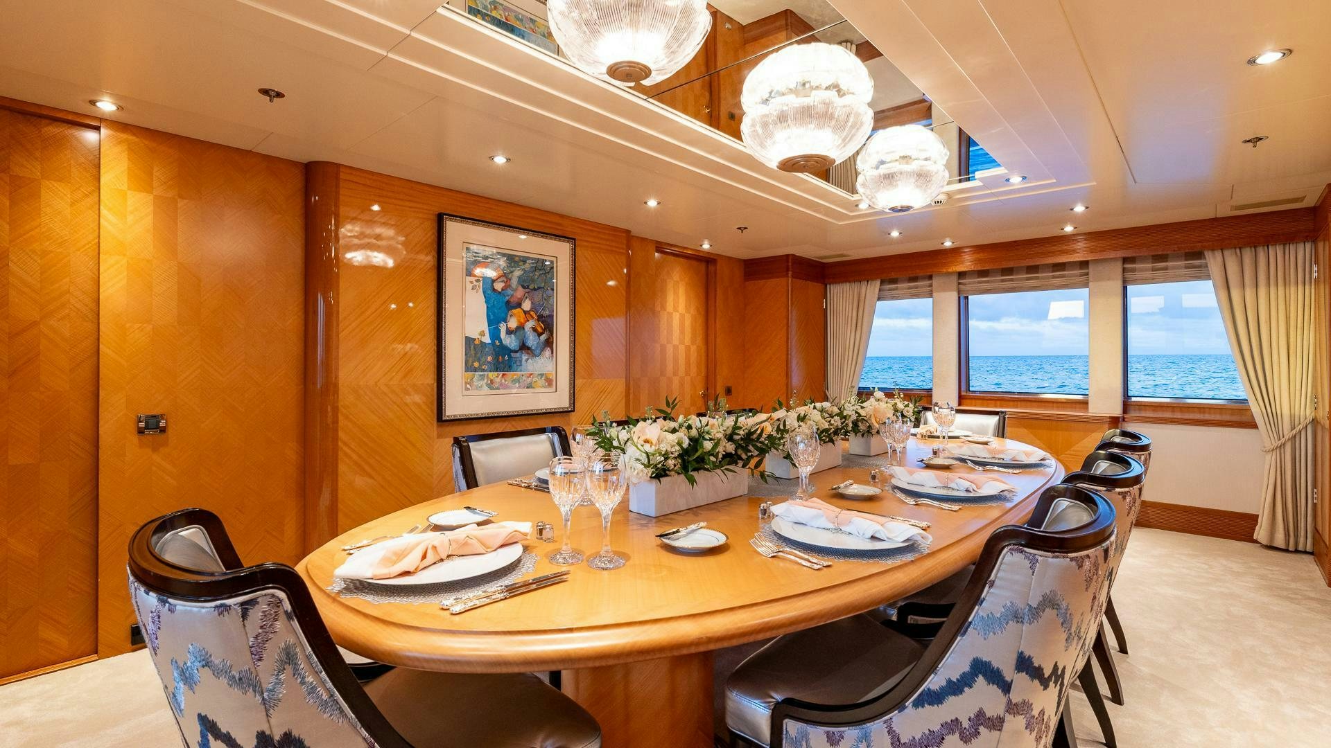 a dining table with plates and chairs aboard AMANTI Yacht for Sale