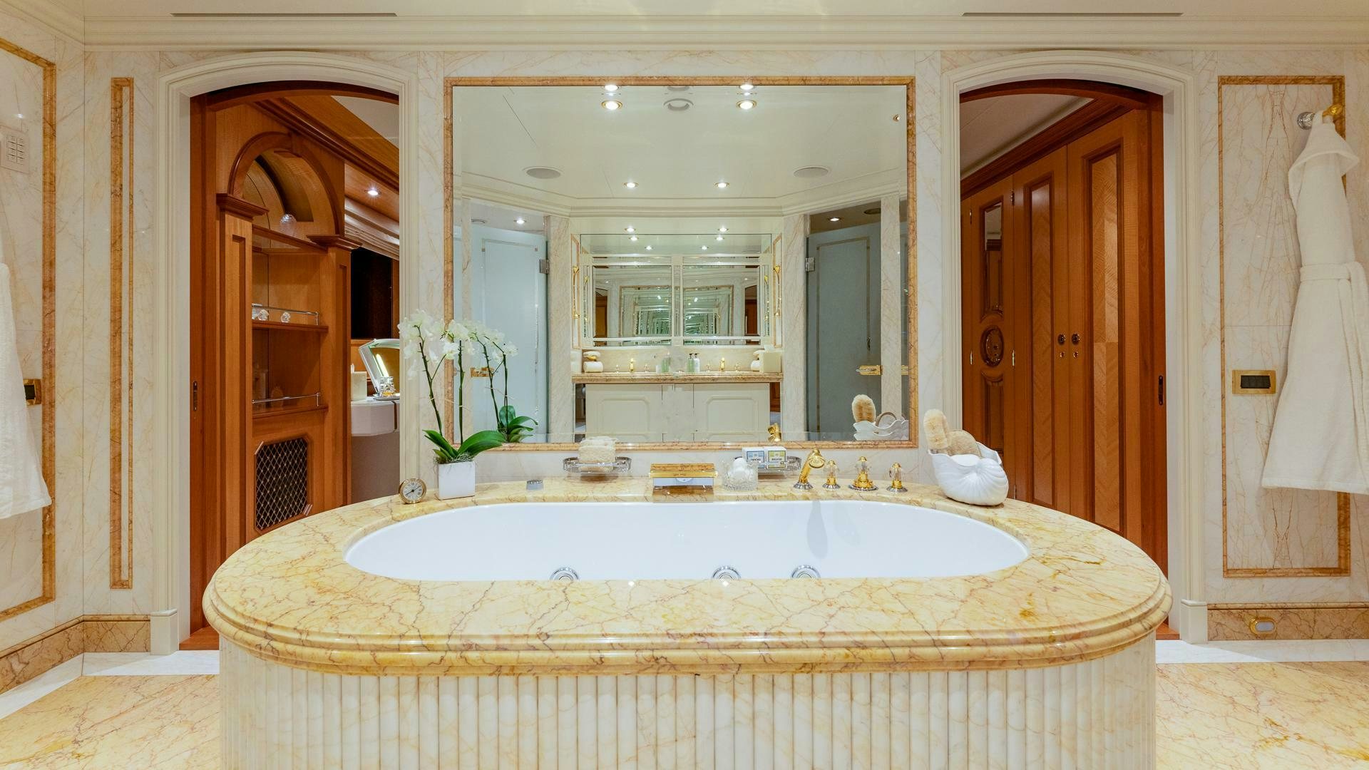 a large bathroom with a large round mirror aboard AMANTI Yacht for Sale