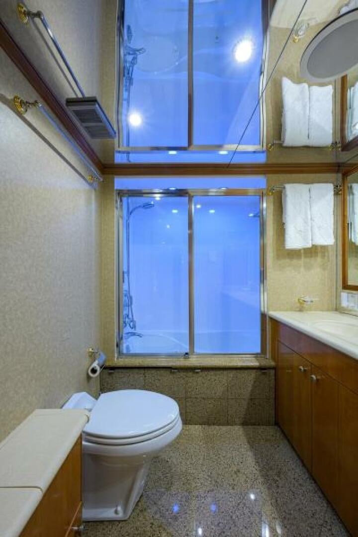 a bathroom with a toilet and a window aboard BELLAGIO Yacht for Sale
