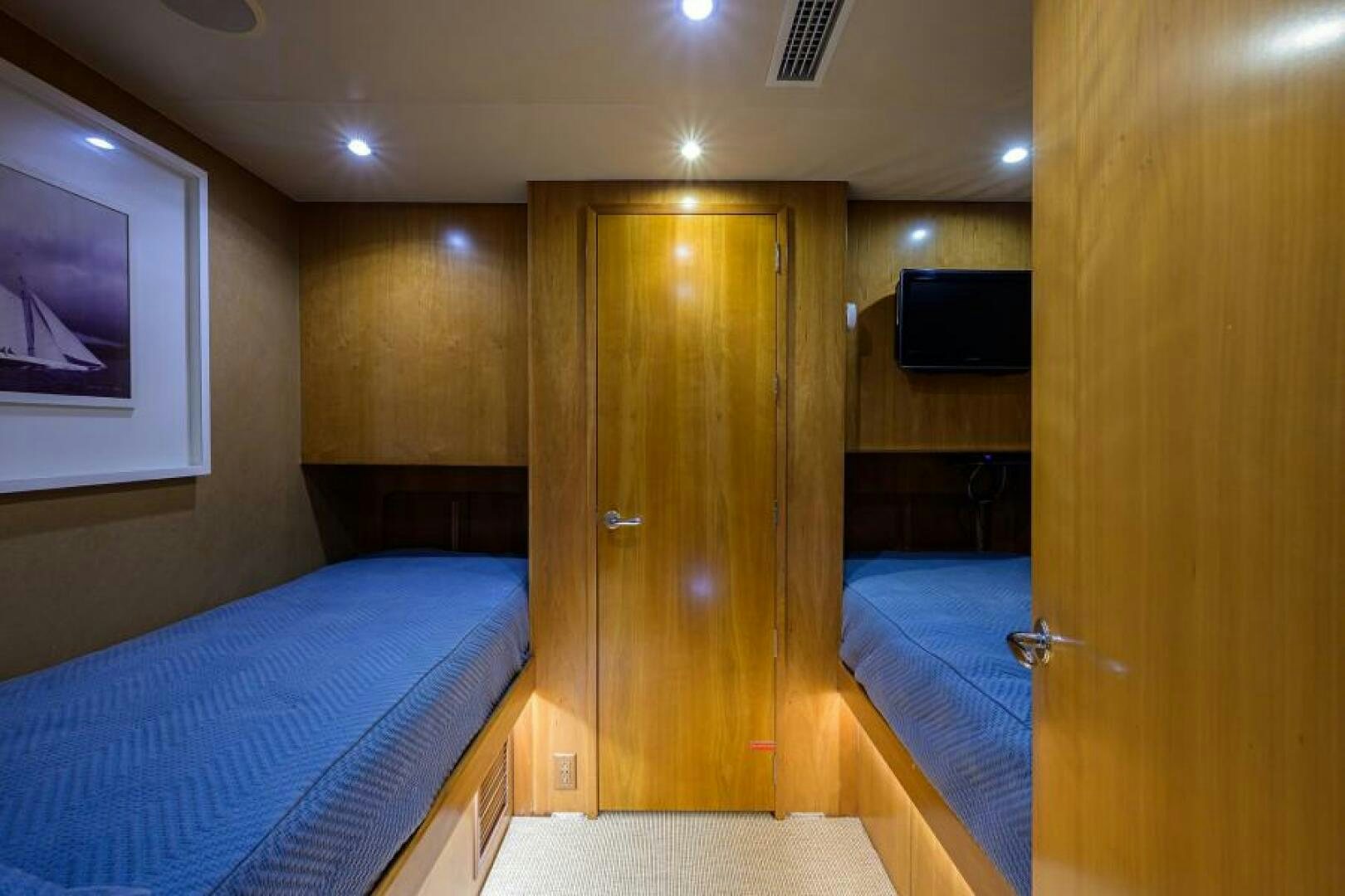 a room with a bed and a wood door aboard BELLAGIO Yacht for Sale