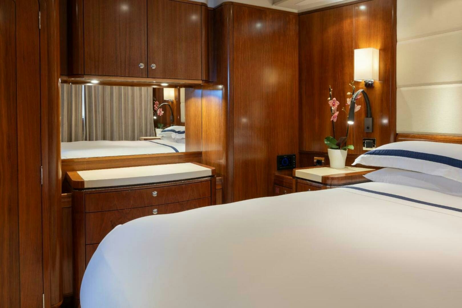 a bedroom with a bed and a mirror aboard ANTARES Yacht for Sale