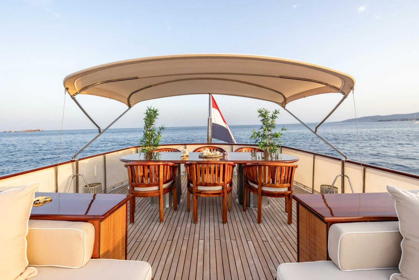 a deck with a table and chairs and a large body of water aboard SISSI Yacht for Sale