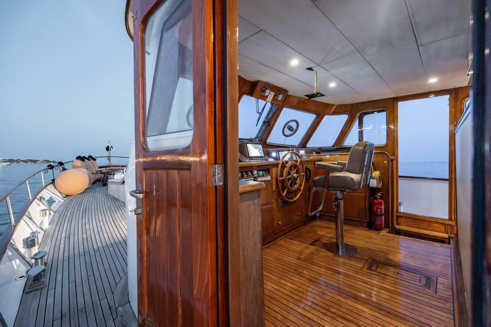 a room with a wood floor and a chair and a table aboard SISSI Yacht for Sale