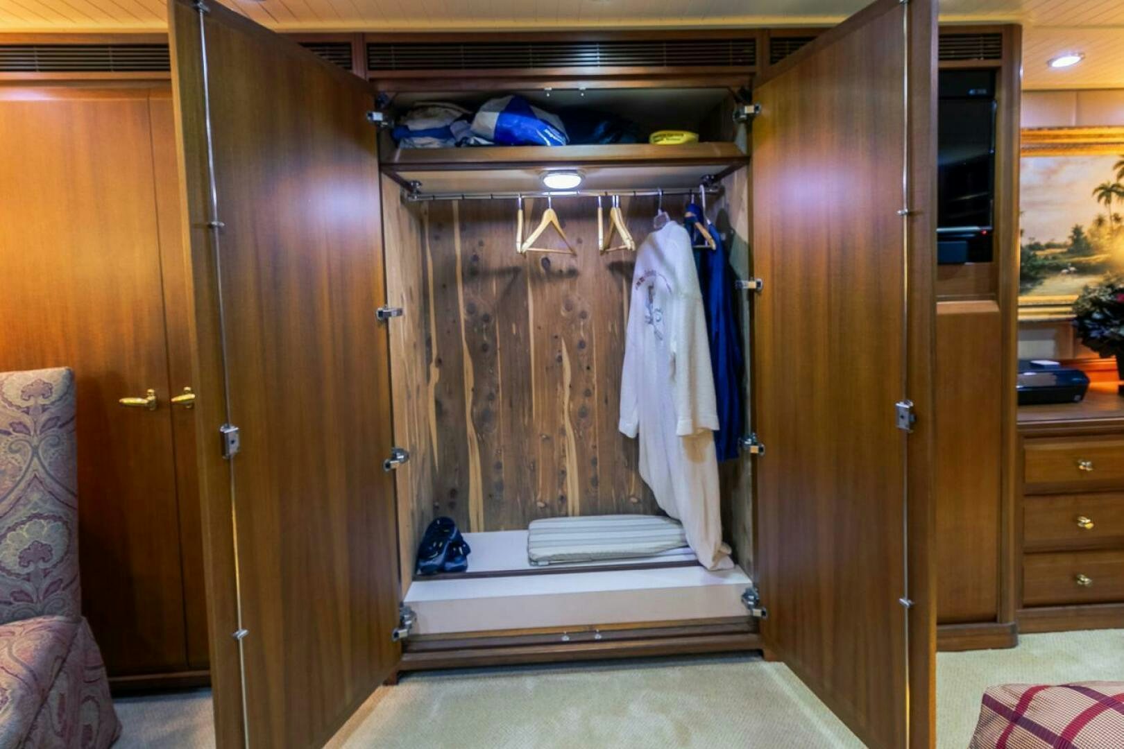 a closet with clothes on the wall aboard CHAIRMAN  Yacht for Sale