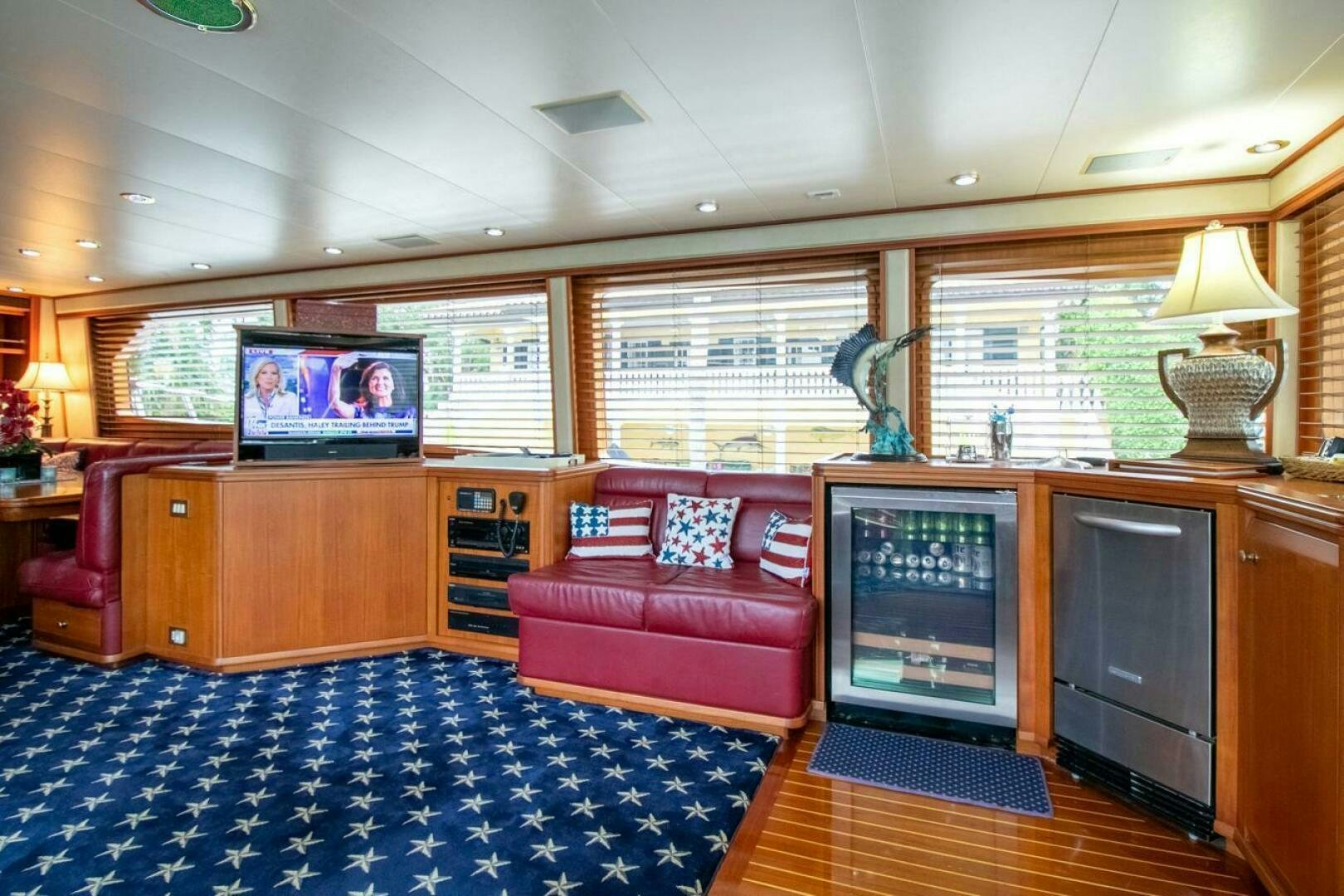 a living room with a red couch aboard CHAIRMAN  Yacht for Sale