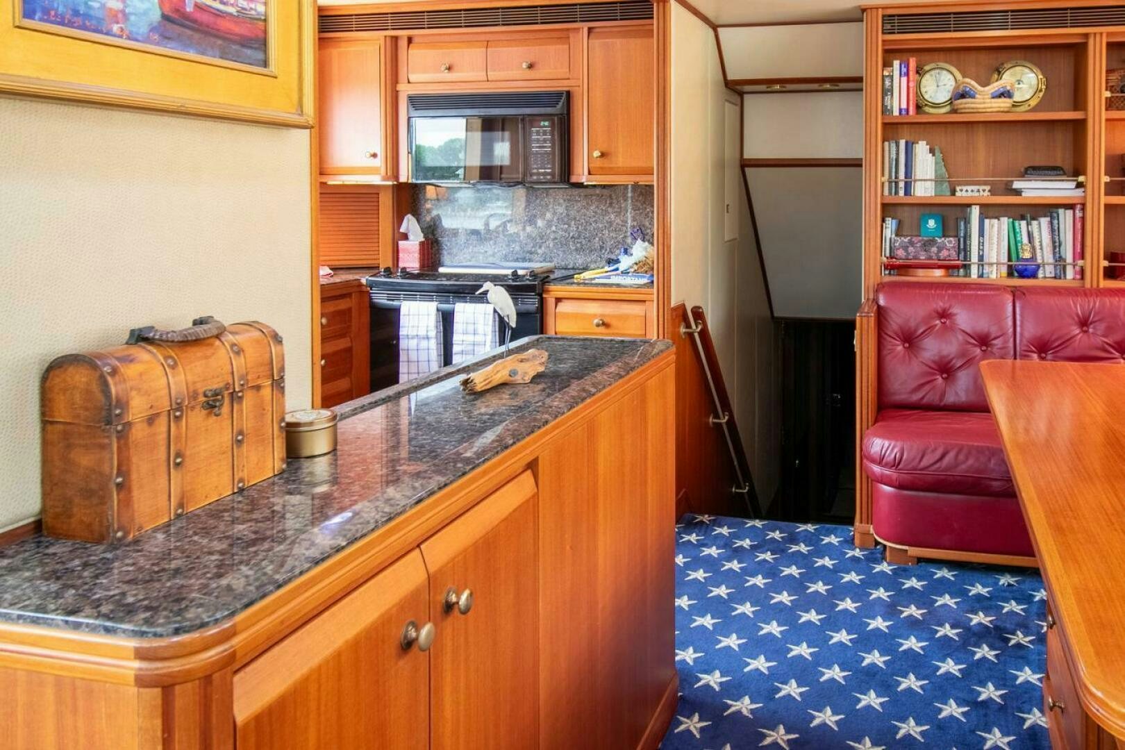 a kitchen with a red couch and a wooden cabinet aboard CHAIRMAN  Yacht for Sale
