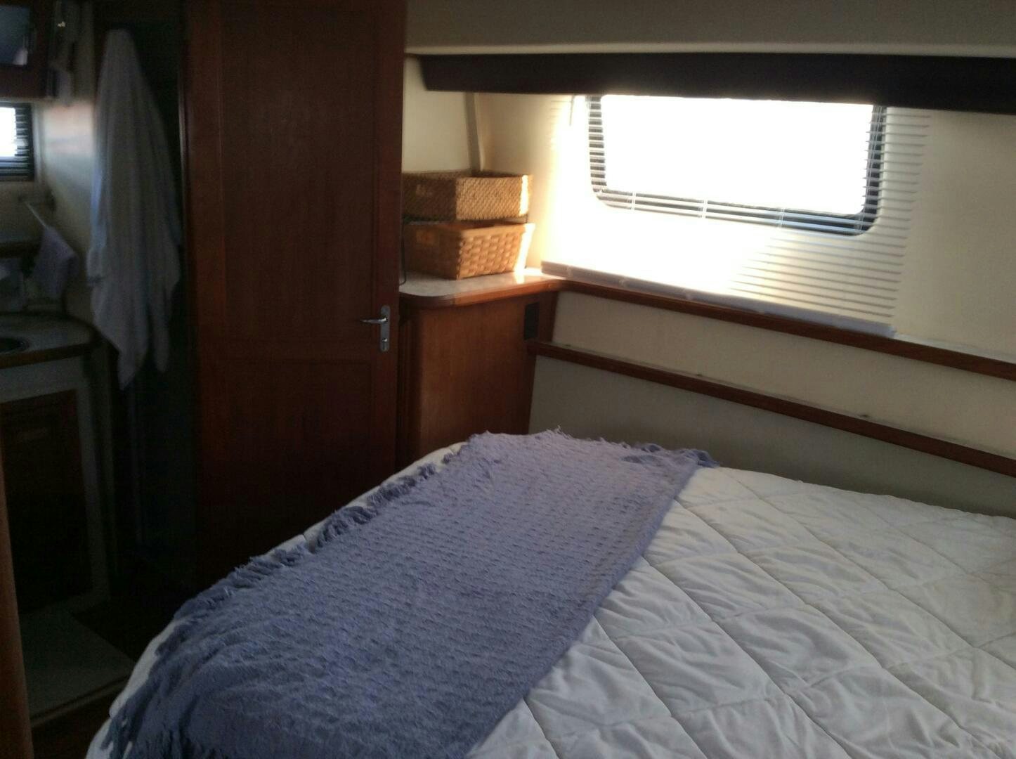a bed with a blue blanket aboard TREES HOUSE Yacht for Sale