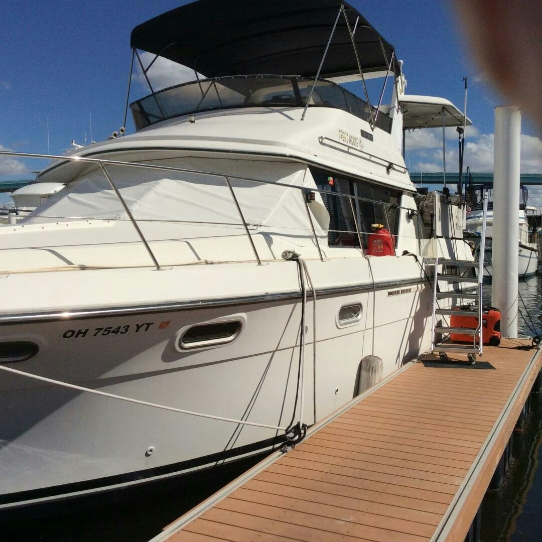 a white yacht on a dock aboard TREES HOUSE Yacht for Sale