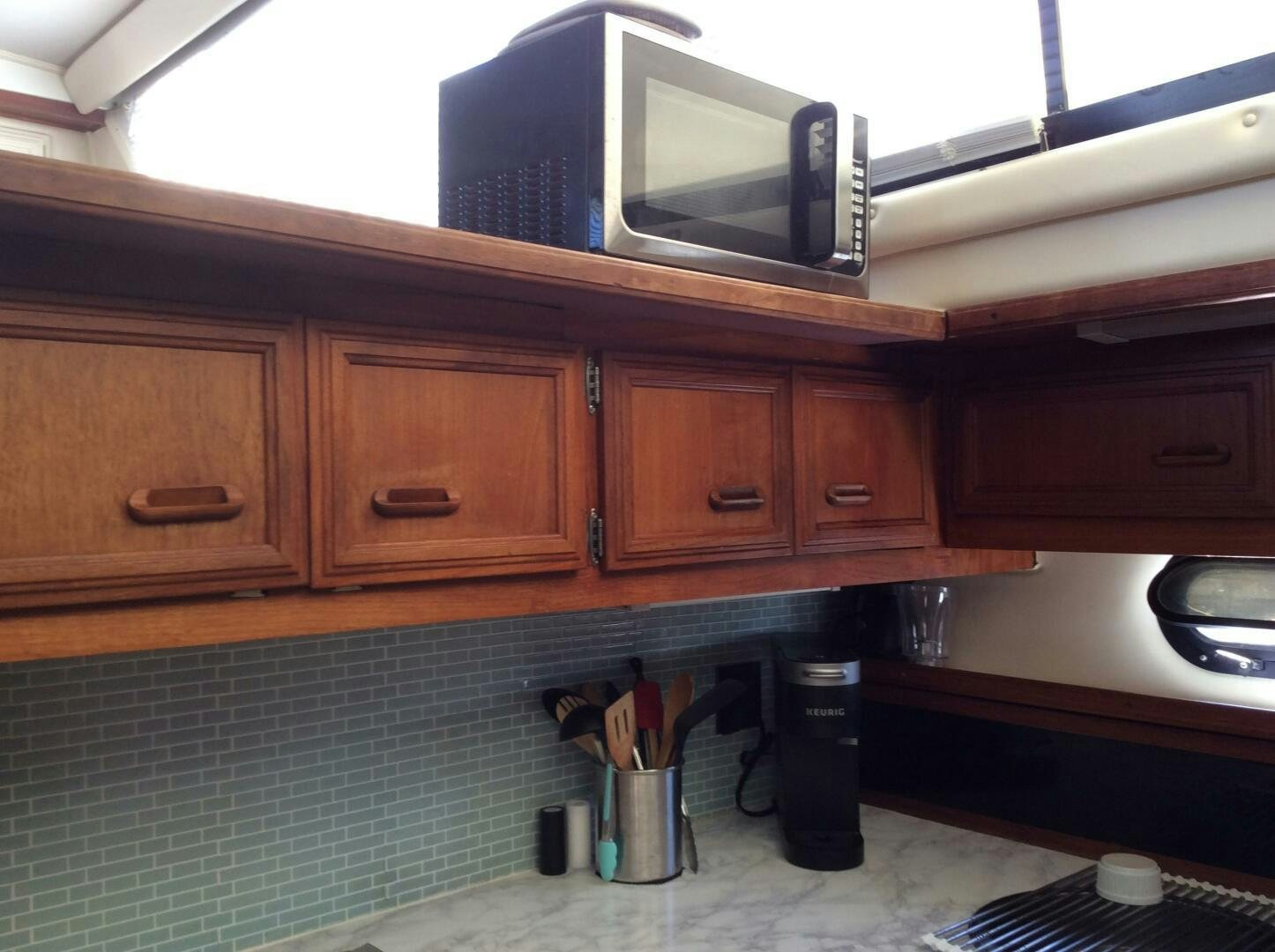 a microwave oven sits on top of a wooden cabinet aboard TREES HOUSE Yacht for Sale