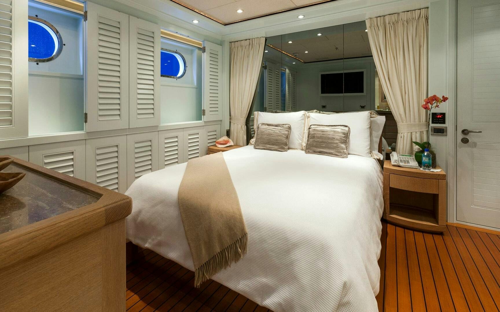 a bedroom with a bed and a desk aboard PERLE BLEUE Yacht for Sale