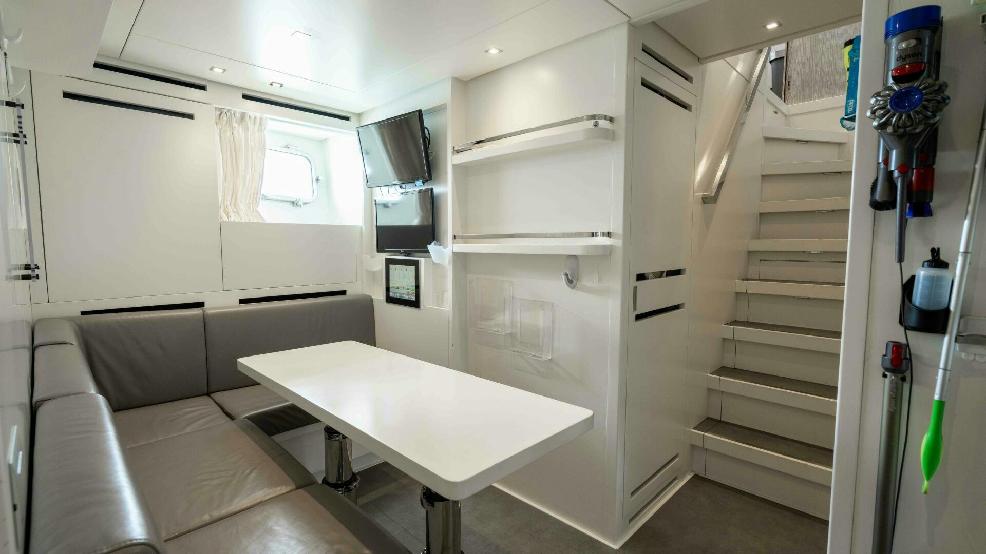 a room with a table and a couch aboard HONEY POT Yacht for Sale