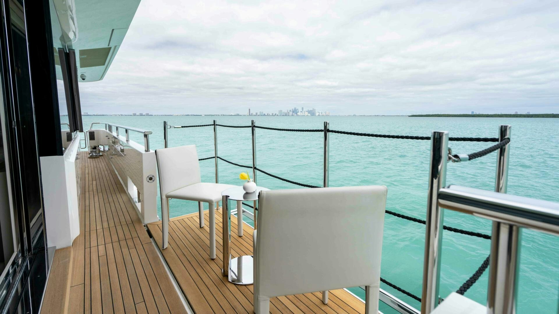 a deck with chairs and a body of water aboard HONEY POT Yacht for Sale