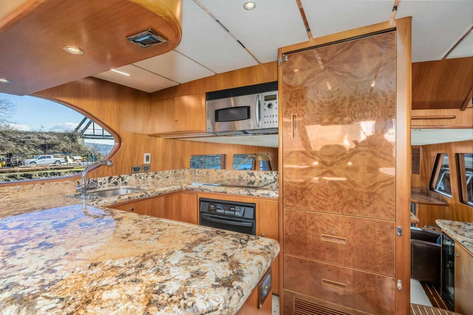 a kitchen with a large marble counter top and wooden cabinets aboard ALL ABORDEAUX Yacht for Sale