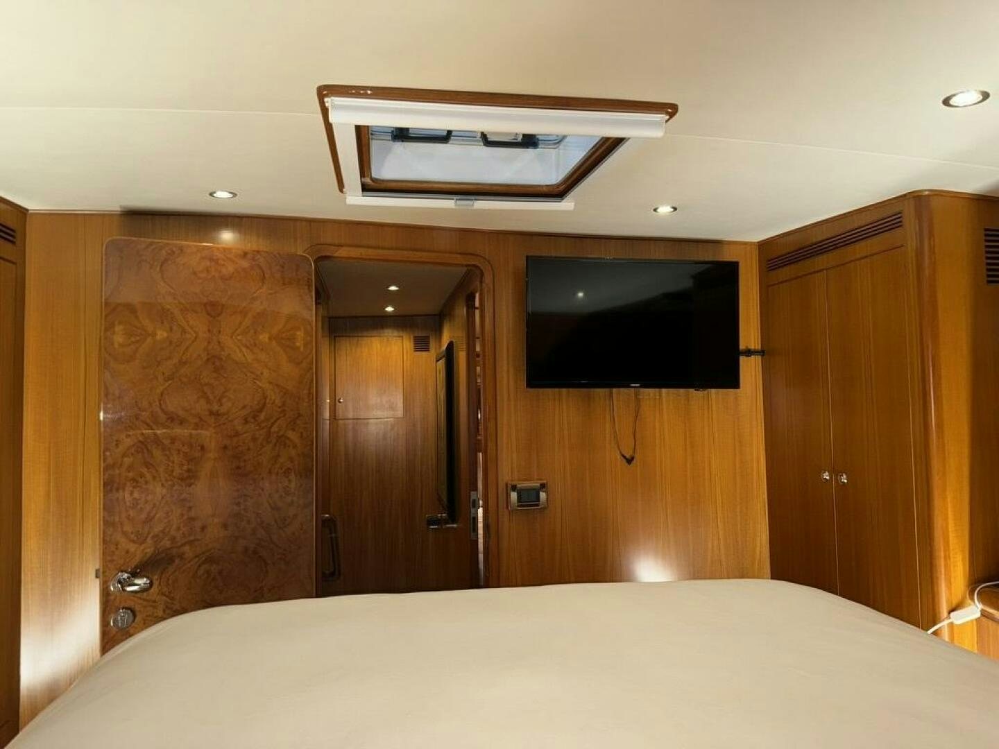 a bed with a television on the wall aboard ALL ABORDEAUX Yacht for Sale