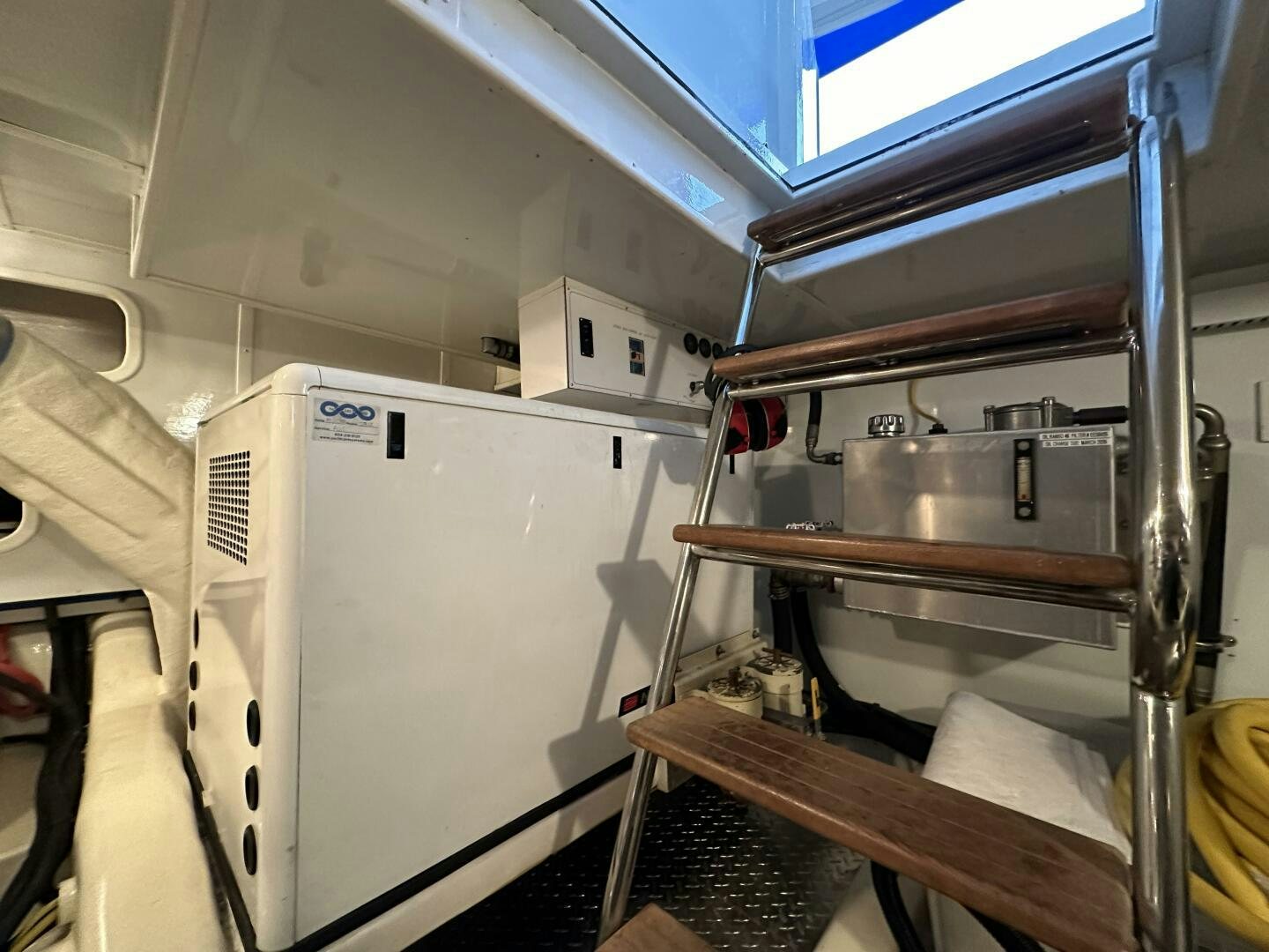 a room with a refrigerator and a shelf with a door open aboard ALL ABORDEAUX Yacht for Sale