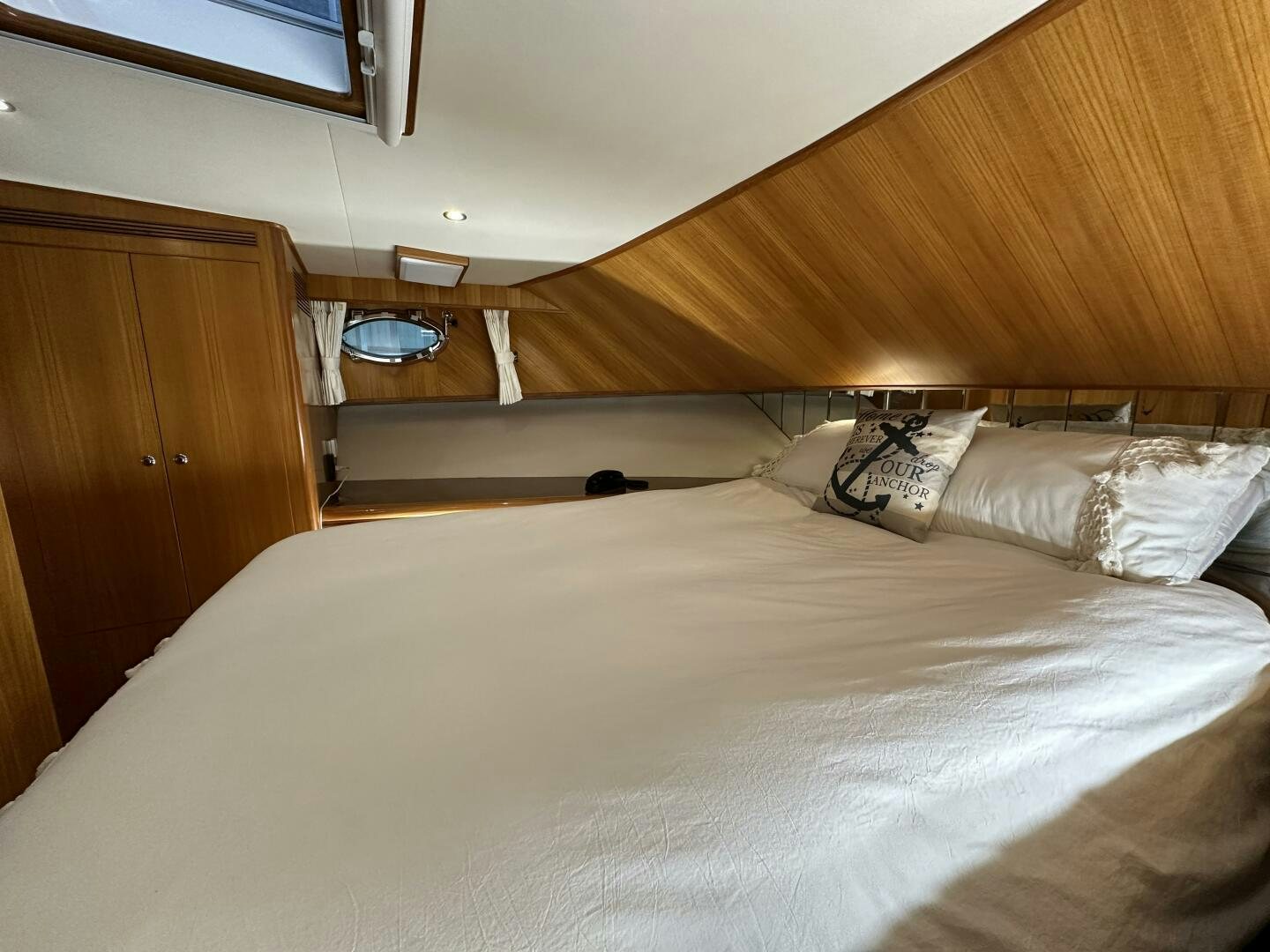 a bed with a white comforter aboard ALL ABORDEAUX Yacht for Sale